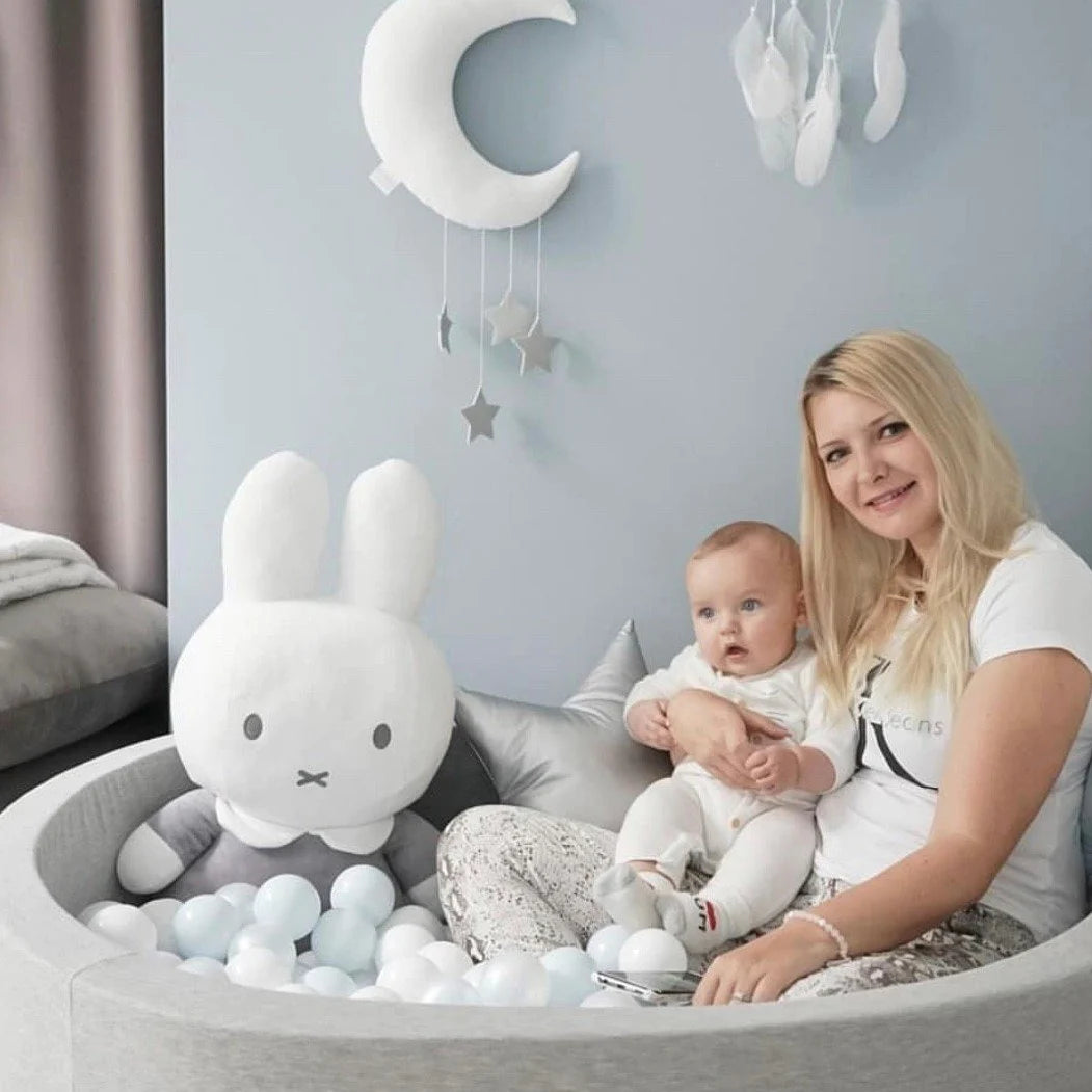 Frau mit Baby im Bällebad